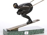 statue d'un skieur sur un socle vert, avec un fond blanc