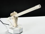 a white lamp that has a hand holding a cigarette in it