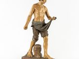 statue en bronze représentant un homme coiffé d'un chapeau et vêtu d'une chemise, assis sur un rocher