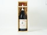 une bouteille de vin dans un coffret en bois posée sur une surface blanche