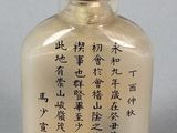 a small glass bottle with writing on it on a table