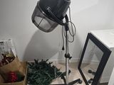 a lamp that is sitting on a tripod next to a christmas tree