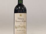 a bottle of red wine sitting on top of a white table