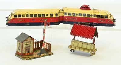 un petit train miniature posé à côté d'une petite maison