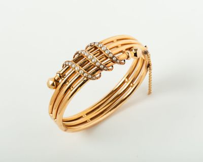 gros plan d'un bracelet en or avec des diamants sur fond blanc