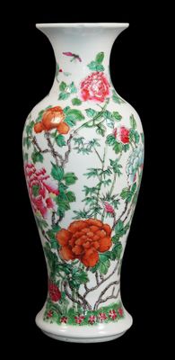 un vase blanc orné de fleurs rouges sur fond noir