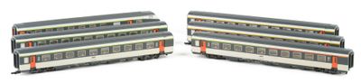 two train cars sitting side by side on a white surface