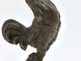 a bronze statue of a rooster on top of a ball