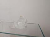 a glass table with a glass frog on it