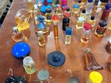 many bottles of perfume sitting on a wooden table
