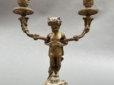 an antique brass candelabra with two candles on a pedestal