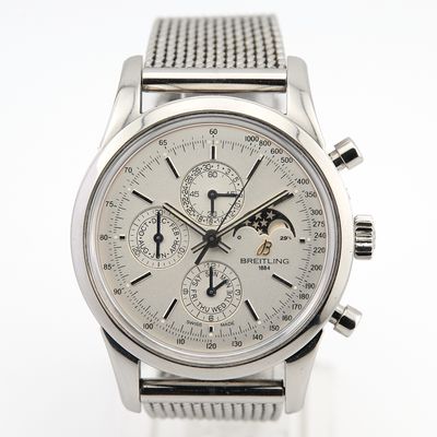 un gros plan d'une montre argentée sur fond blanc
