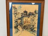 tableau représentant une scène de rue, encadré dans un cadre en bois