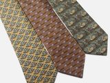 three different colored ties on a white surface with a white background