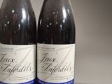two bottles of wine sitting next to each other on a table