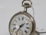 a silver pocket watch with roman numerals on it
