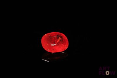 a close up of a red diamond on a black surface
