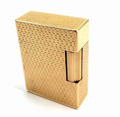 an image of a gold lighter sitting on top of a white surface