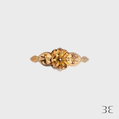 Gros plan sur une bague en or ornée d'une fleur