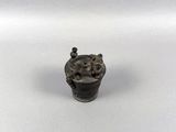 an old bronze figurine of a bear holding a basket of flowers