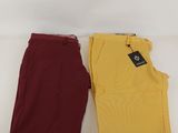 two pairs of yellow and maroon pants on a white surface