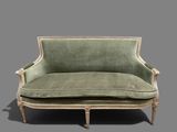 a green couch that is sitting on a gray surface