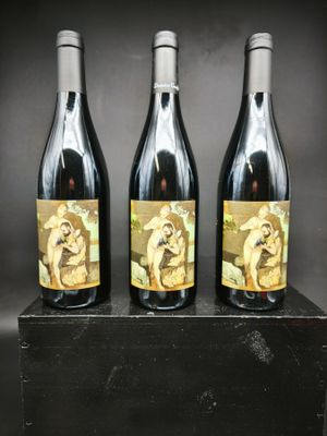 trois bouteilles de vin posées sur un bloc de bois