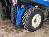 a blue tractor that is parked in the dirt