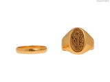 un gros plan d'une bague en or et d'une bague en or sur fond blanc
