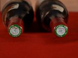 two bottles of wine sitting on a red table