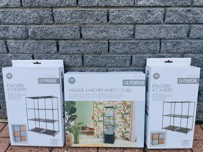 trois bacs à fleurs posés sur un sol en briques, près d'un mur de briques