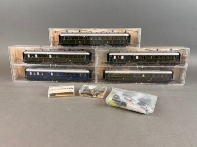 trois trains miniatures sont posés dans des boîtes en plastique sur une table