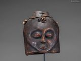 a wooden mask on a stand with a chain around it