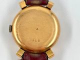 a close up of a watch on a white surface