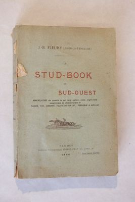 un vieux livre posé sur une table à côté d'un mur blanc