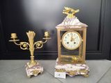 une horloge en or et deux lustres posés au sol