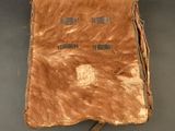 un vieux livre en cuir orné de franges, posé sur une table
