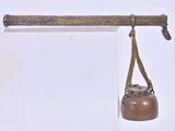 un petit objet métallique suspendu à un crochet fixé au mur