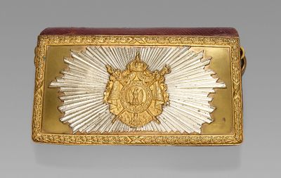 une image représentant une boucle de ceinture en or et en argent ornée d'un motif en rayons de soleil