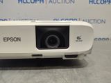 a white projector sitting on top of a table next to a wall