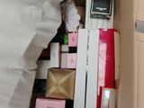 a pile of boxes and a cell phone in the middle of a bed