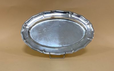 un plateau en argent muni d'une poignée, posé sur une table