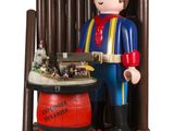 une figurine représentant un homme debout à côté d'un tonneau