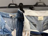 plusieurs paires de jeans suspendues à un portant dans un magasin de vêtements