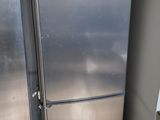 two refrigerators that are next to each other in a room