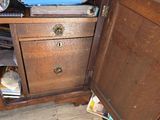 a wooden cabinet with a drawer on top of it