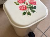 a white toilet with pink roses painted on it