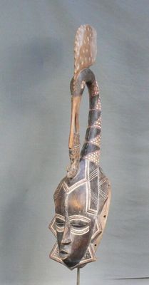 Masque en bois à patine sombre rehaussé de polychromie figur…