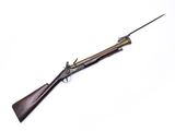 un vieux fusil avec un canon en bois et une poignée en métal