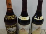 three bottles of wine are lined up on a tile floor